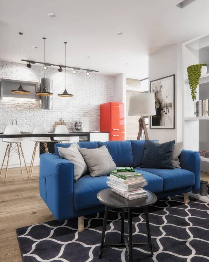 акцентний синій диван у сучасній скандинавській квартирі студії